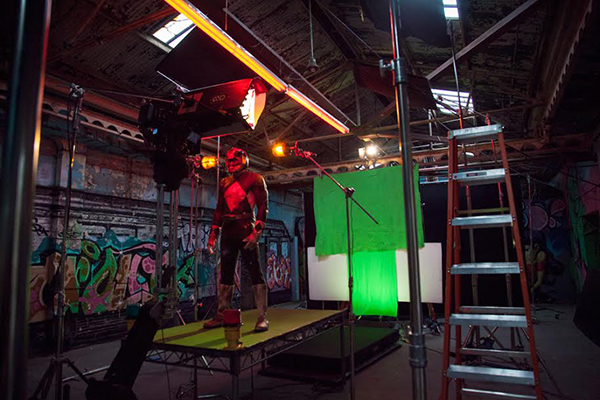 Behind the scenes shot of a Power Ranger in front of a green screen